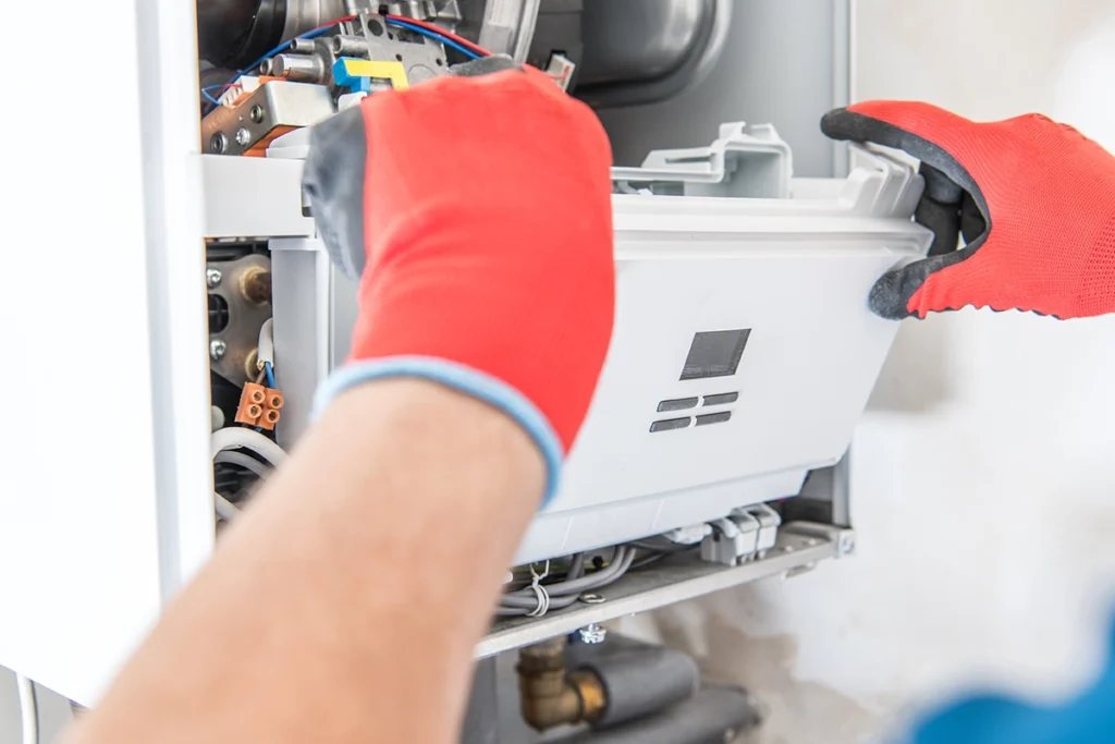 Technician inspecting a furnace limit switch inside a residential heating system