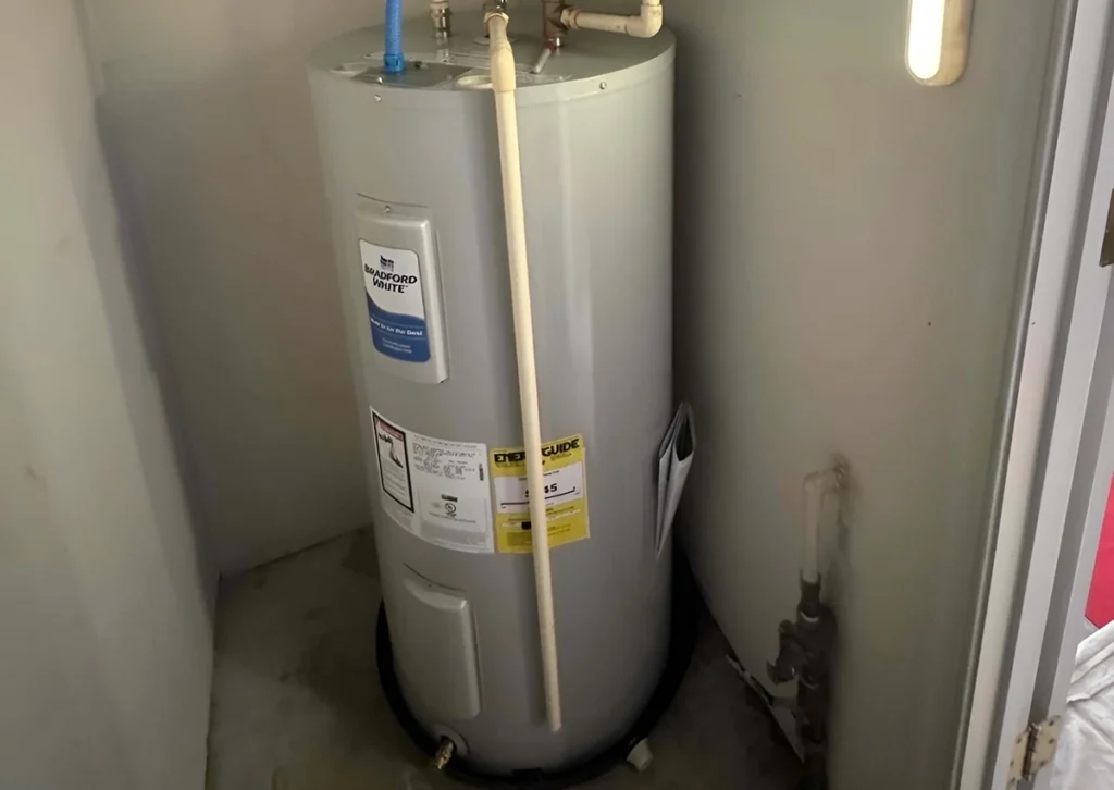 Residential tank water heater installed in utility closet showing how long does a water heater take to heat up in typical home systems