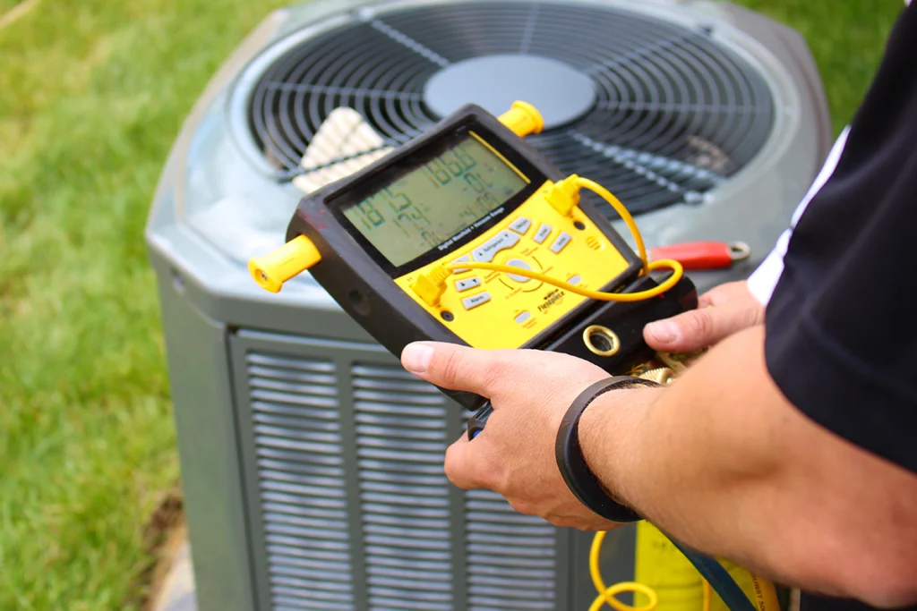 Technician diagnosing an outside ac unit not turning on with HVAC testing equipment at an outdoor condenser
