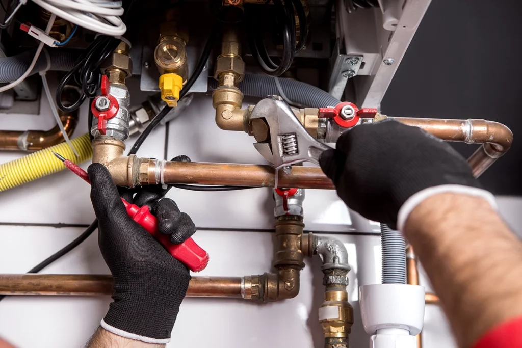 Winter plumbing emergency services: technician working on copper plumbing lines and shutoff valves during a plumbing repair